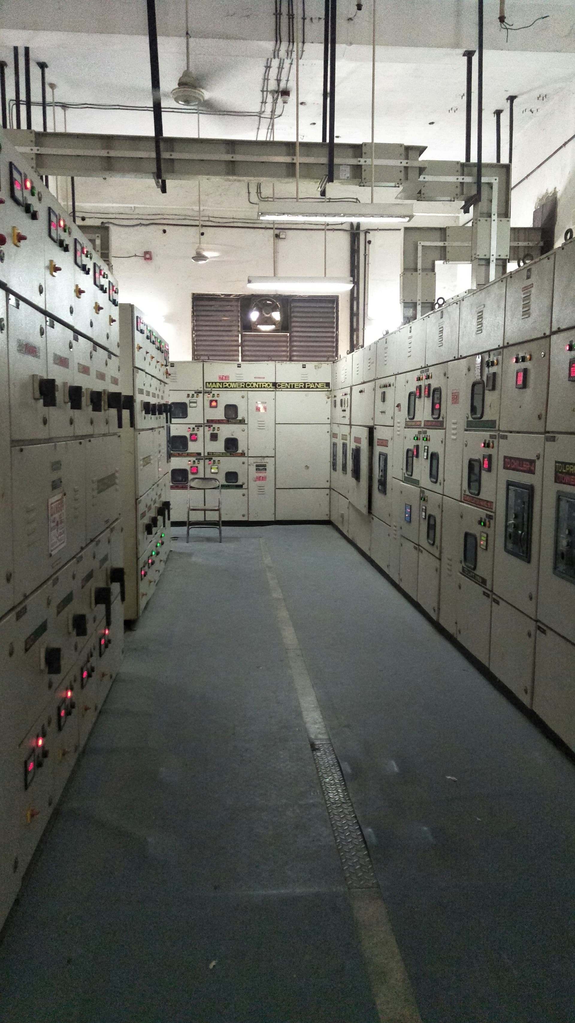 Sala de painéis com fileira de cubículos de controle e proteção de uma subestação