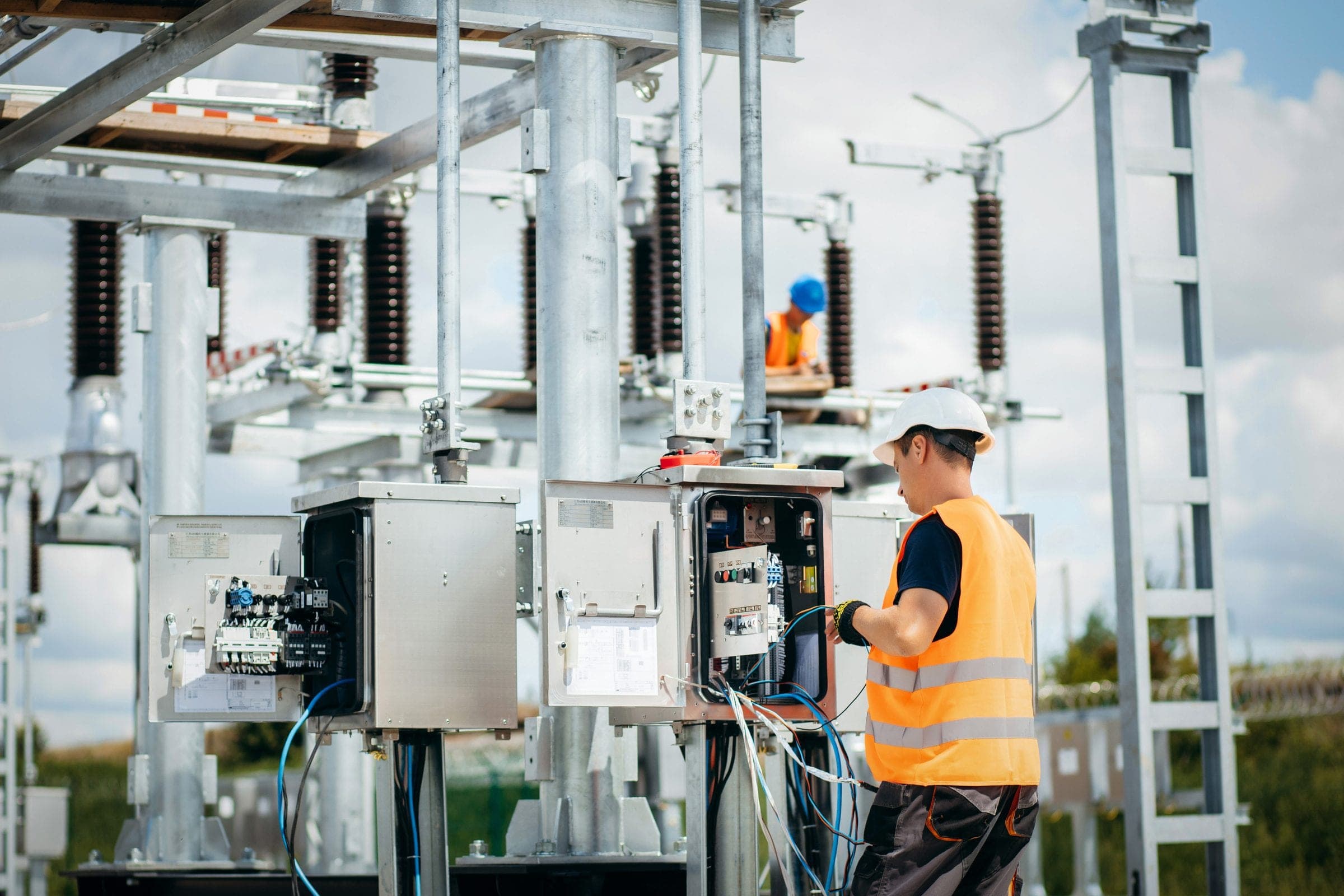 Equipe técnica trabalhando em painéis de campo durante a integração de um retrofit em subestação energizada